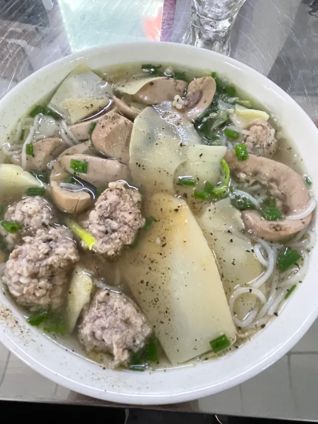 Rice noodle soup with large bamboo shoots, meatballs and slices of cooked meat