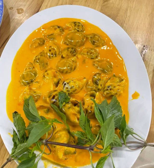 Snails in a glossy orange sauce with fresh herbs