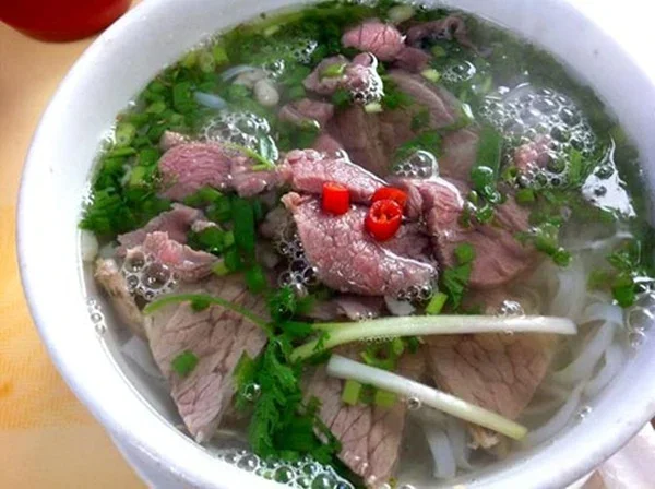 Beef phở with fresh herbs and red chilli