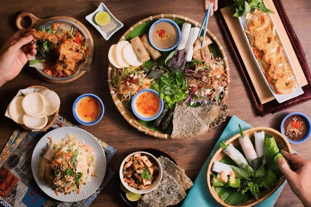 A shared table of Vietnamese dishes, herbs and dipping sauces