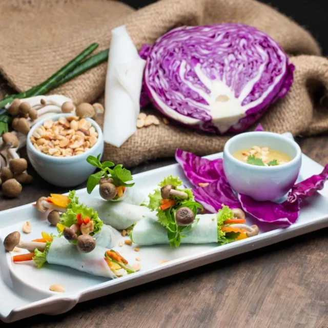 Fresh herbs, rice noodles and vegetarian curries on a wooden table